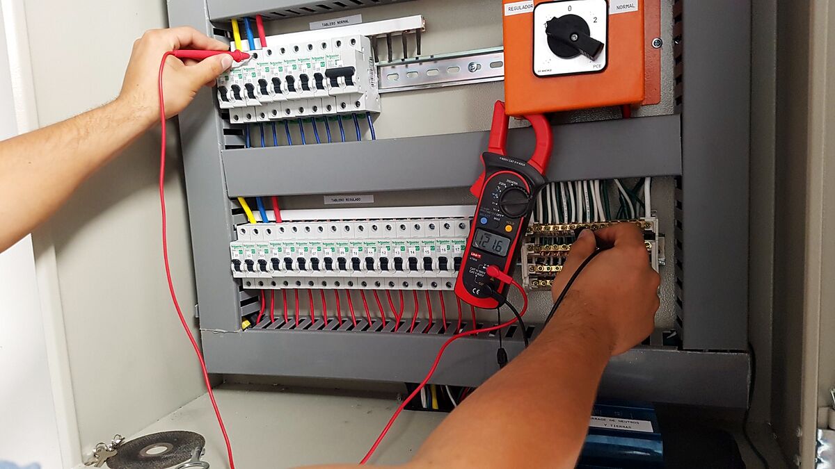 Técnico de ADN midiendo tensión en tablero regulado